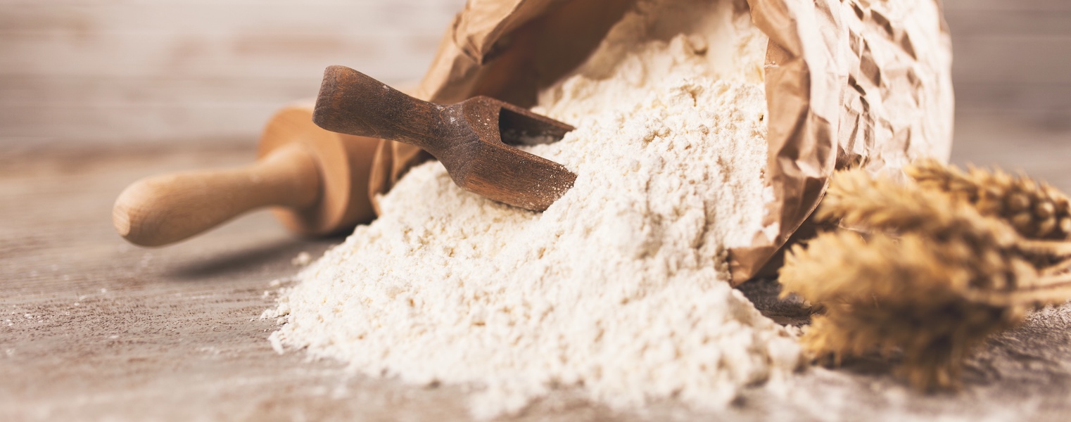 Bag of flour on wooden background